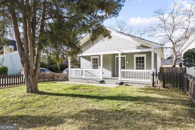 bungalow with a porch, a front lawn, and fence