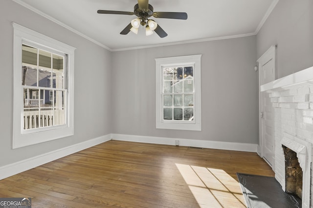 unfurnished living room featuring baseboards, hardwood / wood-style floors, a fireplace, and ornamental molding