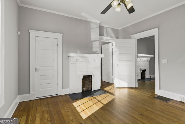 unfurnished living room with visible vents, ornamental molding, wood-type flooring, a fireplace, and baseboards