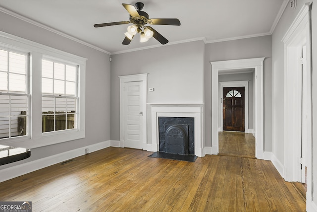 unfurnished living room with a fireplace with flush hearth, crown molding, baseboards, and hardwood / wood-style flooring