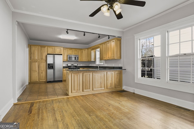 kitchen with visible vents, ornamental molding, stainless steel appliances, hardwood / wood-style flooring, and dark countertops