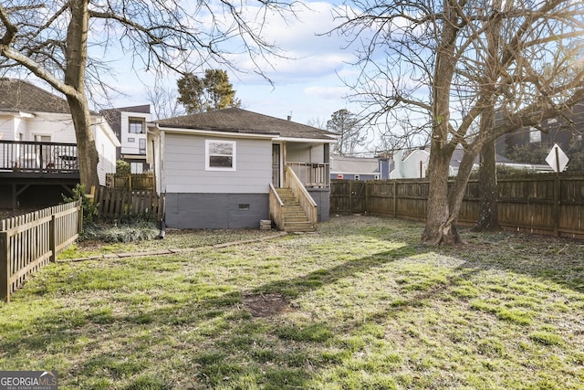 back of house featuring a fenced backyard, a lawn, roof with shingles, and crawl space