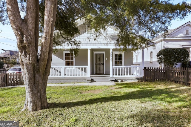 bungalow-style home featuring a porch, a front lawn, and fence