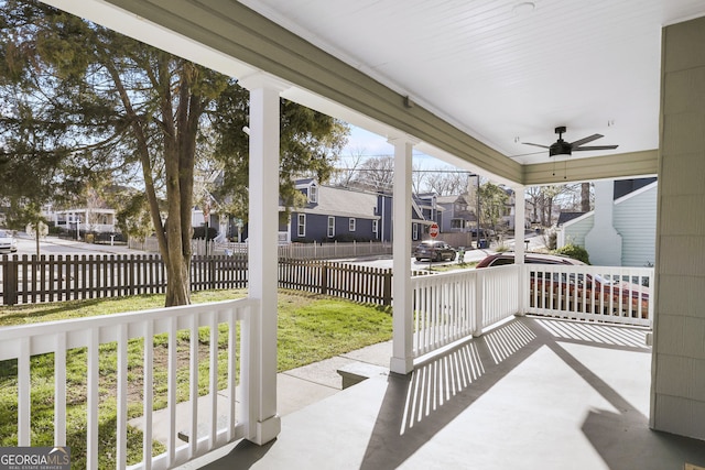 view of patio / terrace featuring fence, a ceiling fan, covered porch, and a residential view