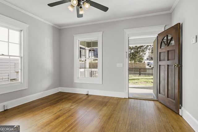 entrance foyer with baseboards, crown molding, and hardwood / wood-style flooring