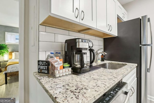 1415 Vesta Ave, Atlanta, GA 30344 - kitchen featuring decorative backsplash, stainless steel appliances, white cabinets, and light stone counters
