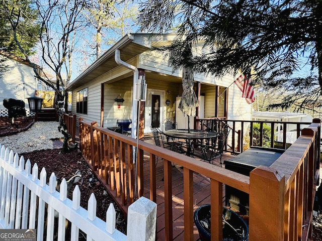 wooden terrace featuring outdoor dining area and fence