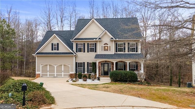 view of front of property featuring central AC unit, covered porch, a garage, driveway, and a front lawn