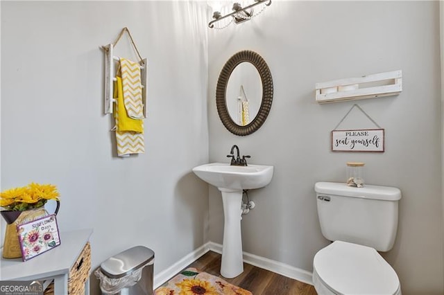 bathroom featuring toilet, baseboards, and wood finished floors