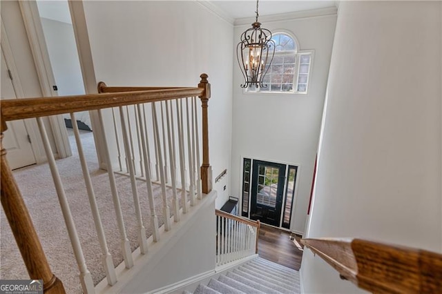 entryway with ornamental molding, wood finished floors, a healthy amount of sunlight, and an inviting chandelier