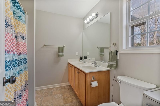 full bathroom with curtained shower, toilet, a sink, baseboards, and double vanity