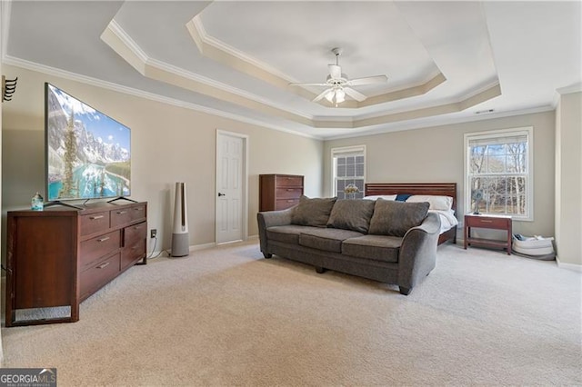 bedroom featuring light carpet, a tray ceiling, ornamental molding, and baseboards