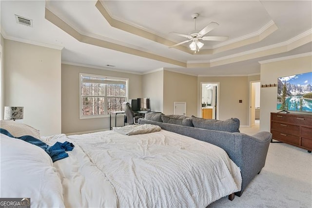 bedroom featuring ornamental molding, a tray ceiling, visible vents, and light colored carpet