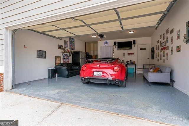 garage featuring freestanding refrigerator and a garage door opener