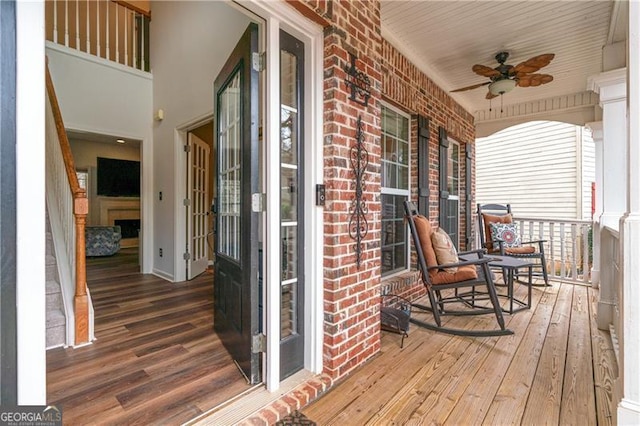 wooden terrace featuring covered porch and ceiling fan