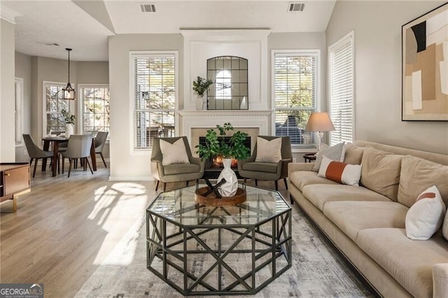 sunroom featuring a healthy amount of sunlight, visible vents, and a large fireplace