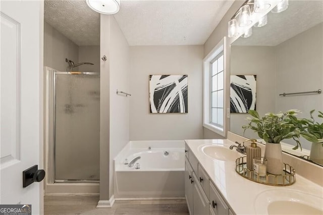 full bath featuring a stall shower, wood finished floors, a sink, and a bath