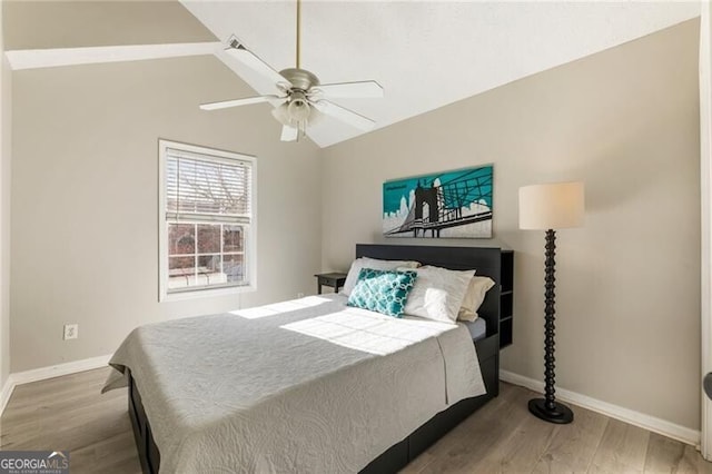 bedroom with lofted ceiling, a ceiling fan, baseboards, and wood finished floors