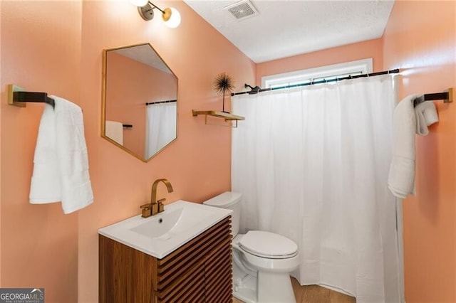 bathroom with toilet, a shower with curtain, visible vents, and vanity