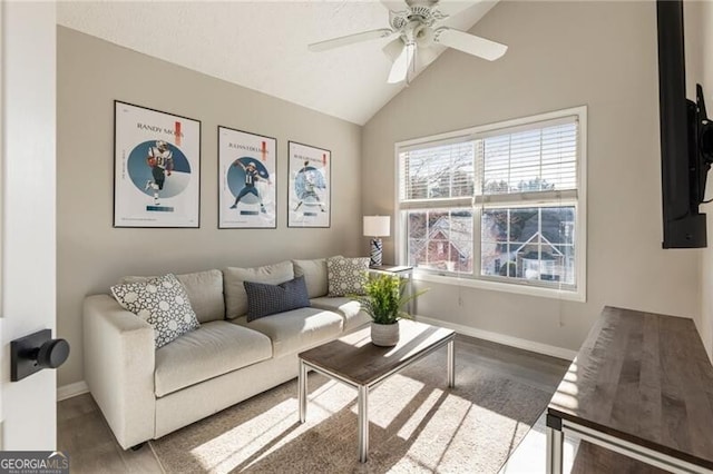 living area with vaulted ceiling, wood finished floors, a ceiling fan, and baseboards