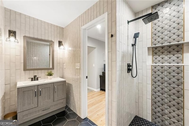 full bathroom with a stall shower, tile patterned flooring, tile walls, and vanity