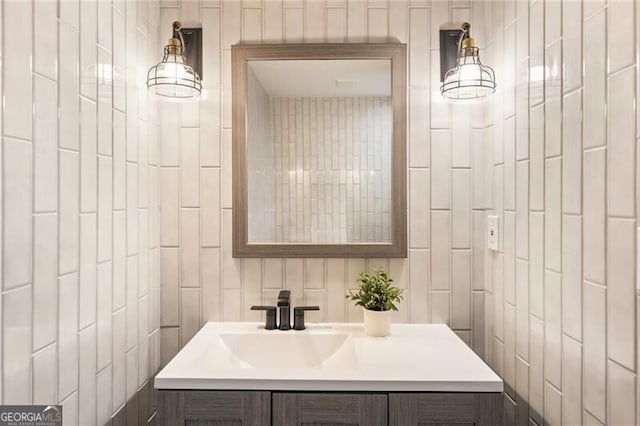 bathroom featuring vanity and tile walls