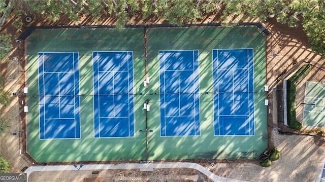 view of side of property with a tennis court and fence