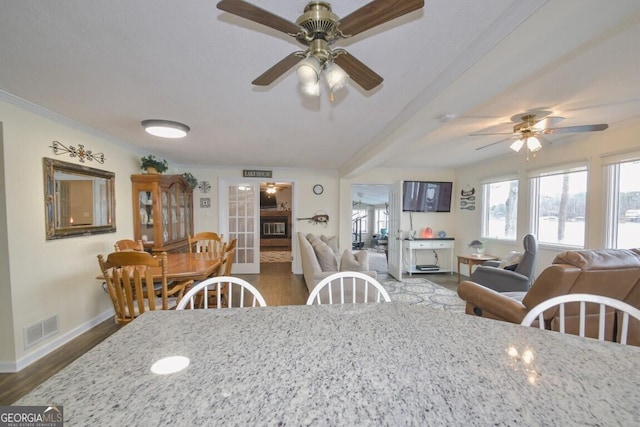 dining room featuring a ceiling fan, wood finished floors, visible vents, baseboards, and crown molding