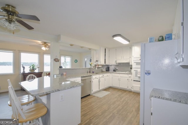 kitchen with decorative backsplash, light wood-style flooring, a peninsula, white cabinets, and white appliances