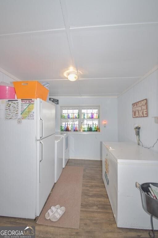 kitchen featuring light countertops, washer / clothes dryer, wood finished floors, and freestanding refrigerator