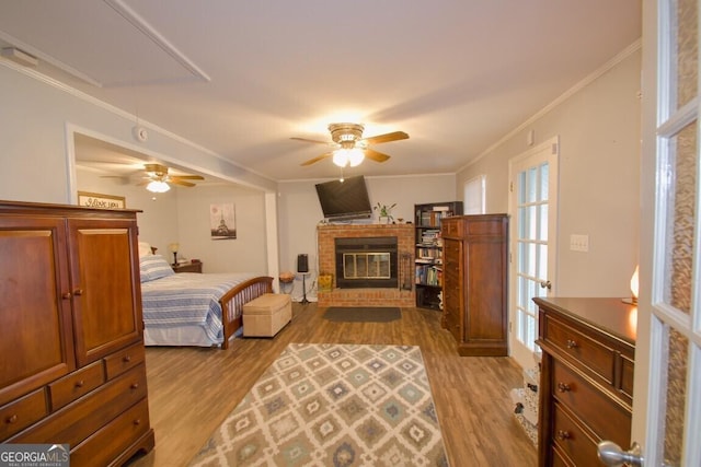 bedroom featuring attic access, crown molding, and wood finished floors