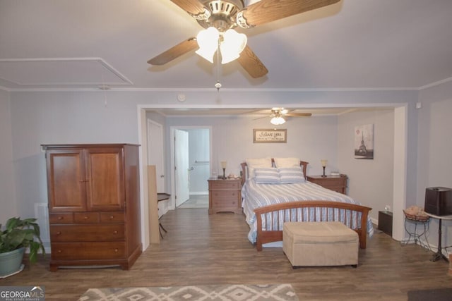 bedroom featuring ceiling fan, attic access, wood finished floors, and ornamental molding