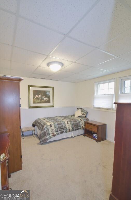 bedroom with a drop ceiling and carpet floors