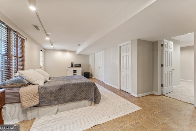 bedroom with visible vents, rail lighting, and baseboards