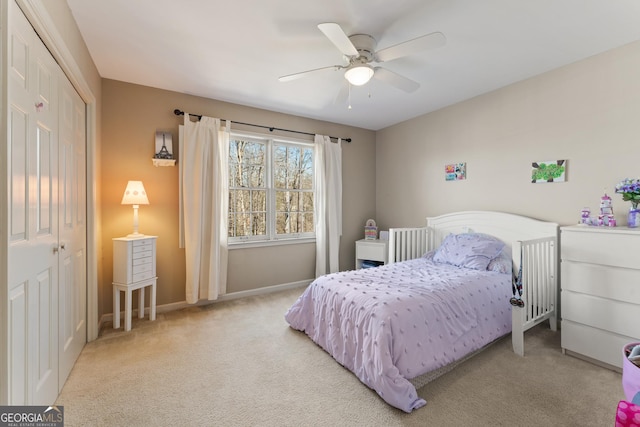 bedroom with a closet, carpet flooring, baseboards, and a ceiling fan