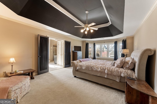 carpeted bedroom featuring a tray ceiling, connected bathroom, and ornamental molding