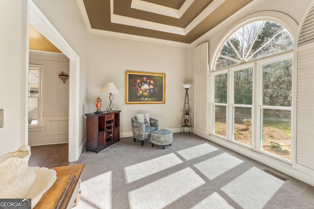 sitting room featuring carpet flooring, crown molding, plenty of natural light, and visible vents