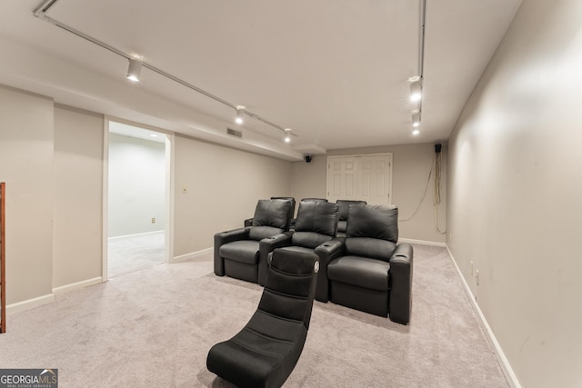 home theater room featuring baseboards, light carpet, visible vents, and track lighting