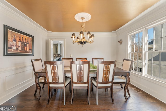 dining space with visible vents, an inviting chandelier, dark wood finished floors, and crown molding