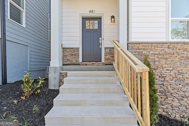 doorway to property featuring stone siding