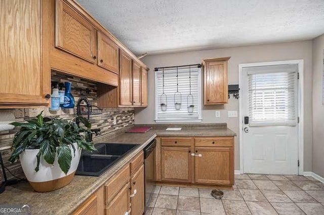 kitchen featuring light tile patterned floors, dishwashing machine, backsplash, and a textured ceiling