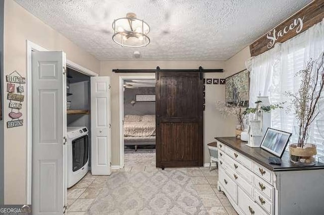 laundry room featuring a barn door, a textured ceiling, and laundry area