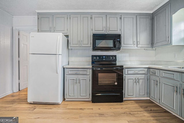 kitchen with light wood-style flooring, gray cabinetry, black appliances, and light countertops