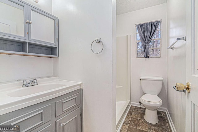 full bath featuring baseboards, walk in shower, toilet, vanity, and a textured ceiling