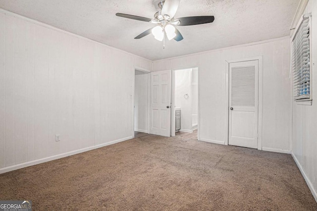 unfurnished bedroom with ensuite bath, a textured ceiling, a ceiling fan, and carpet floors