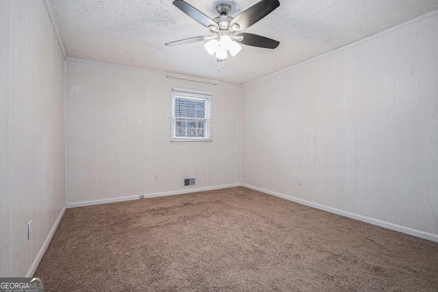 unfurnished room featuring visible vents, a textured ceiling, carpet flooring, baseboards, and ceiling fan