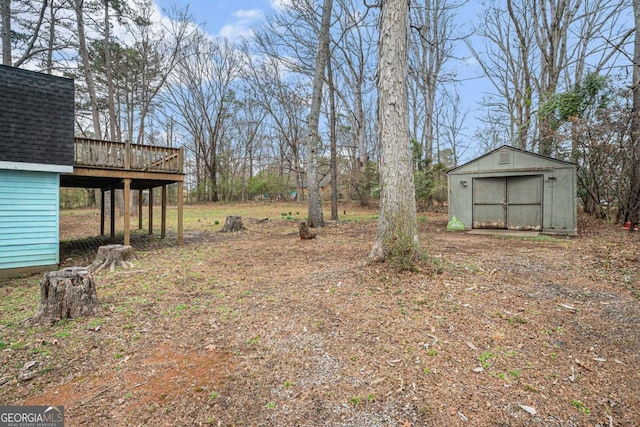 view of yard featuring a deck, an outdoor structure, and a shed