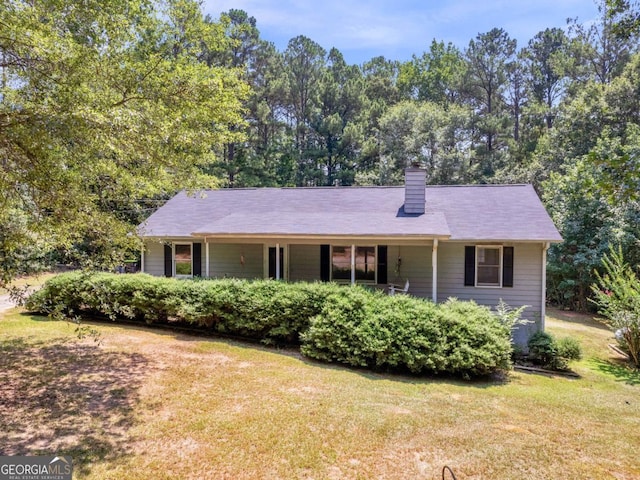 single story home with a front lawn and a chimney