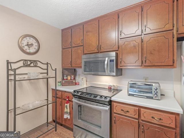 2643 Rocky Creek Rd, Hampton, GA 30228 - kitchen featuring stainless steel appliances, a toaster, a textured ceiling, and light countertops