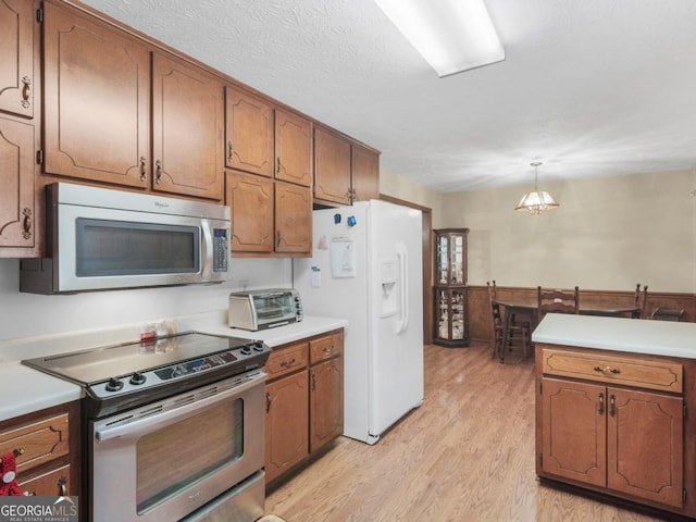 2643 Rocky Creek Rd, Hampton, GA 30228 - kitchen with a toaster, light countertops, light wood-style floors, appliances with stainless steel finishes, and brown cabinets